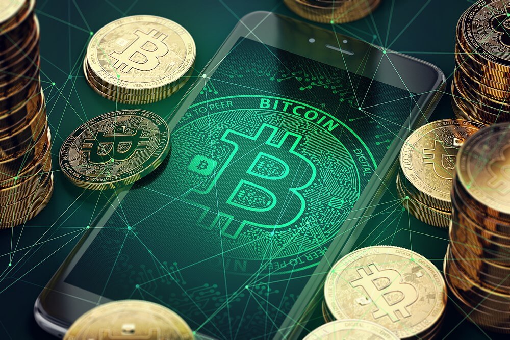 A Bitcoin app is open on a smartphone, with Bitcoins surrounding the device